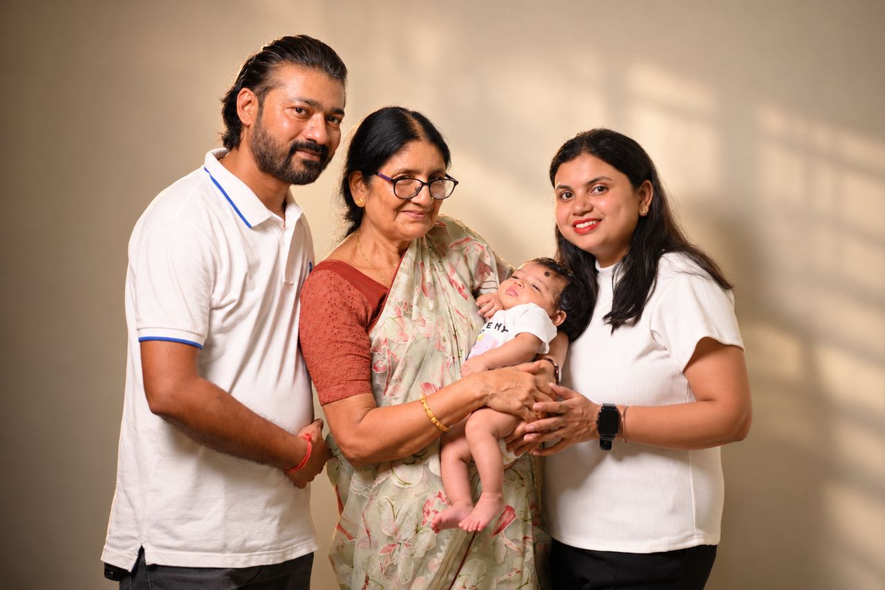 A family portrait: father, grandmother holding the baby, and mother