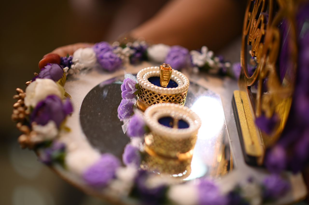 Engagement rings on a decorated tray of purple flowers