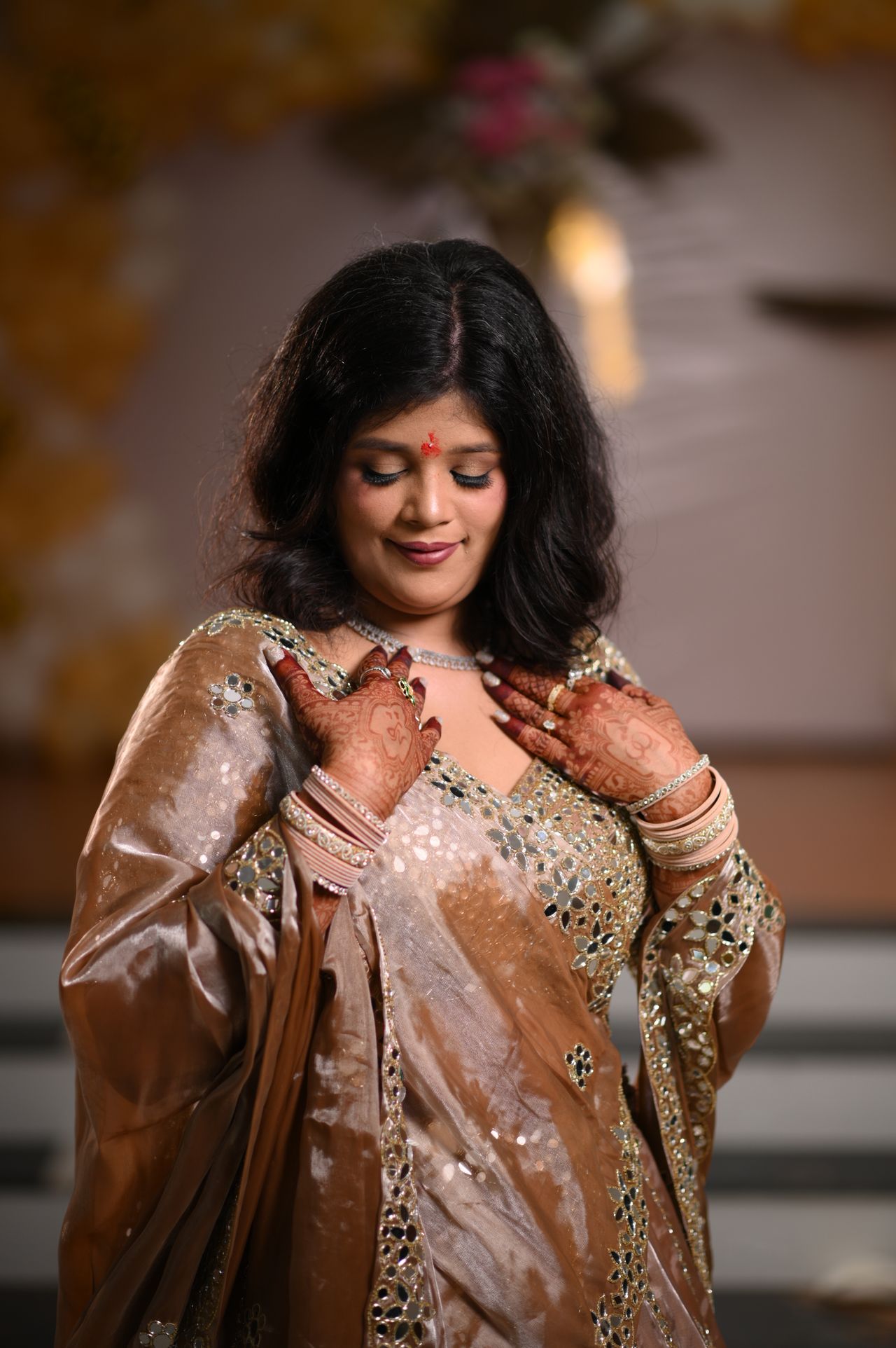 Portrait of the bride-to-be in a bronze sequinned lehenga, hand on her heart