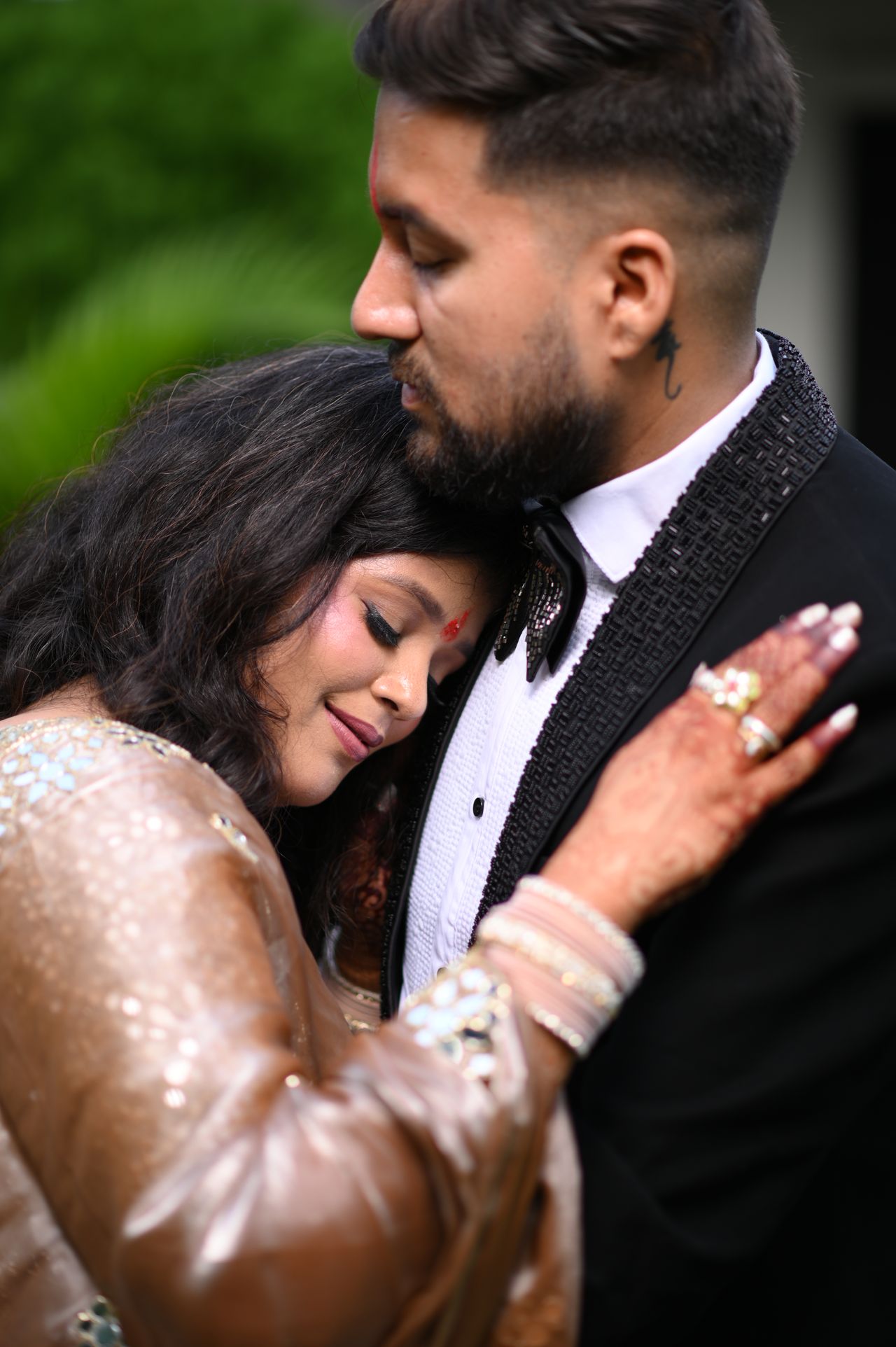 A woman rests her head against her partner's chest, eyes closed