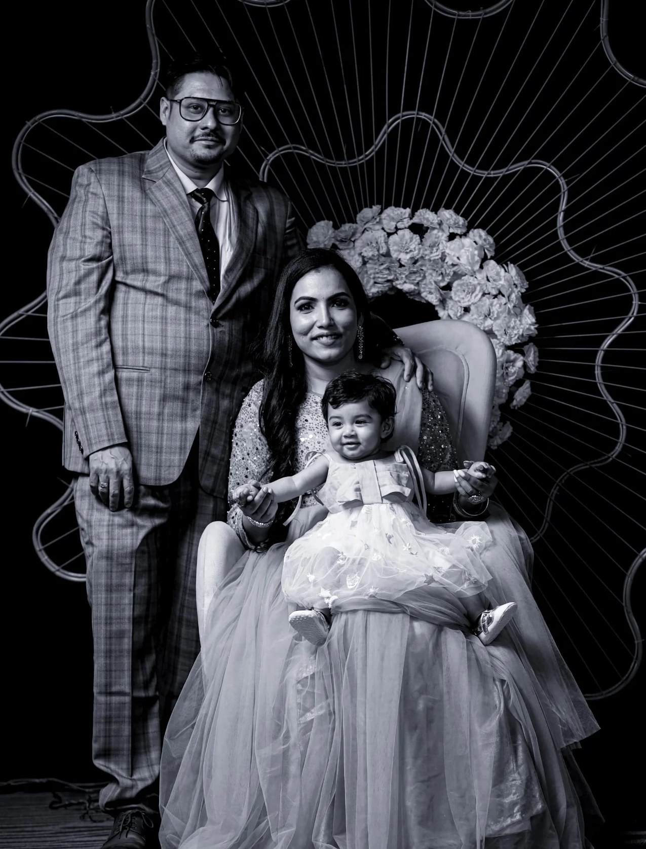 Black and white family portrait with a baby girl on her mother's lap