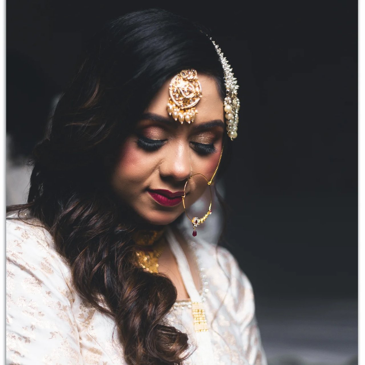 Close portrait of a smiling bride wearing a maang tikka