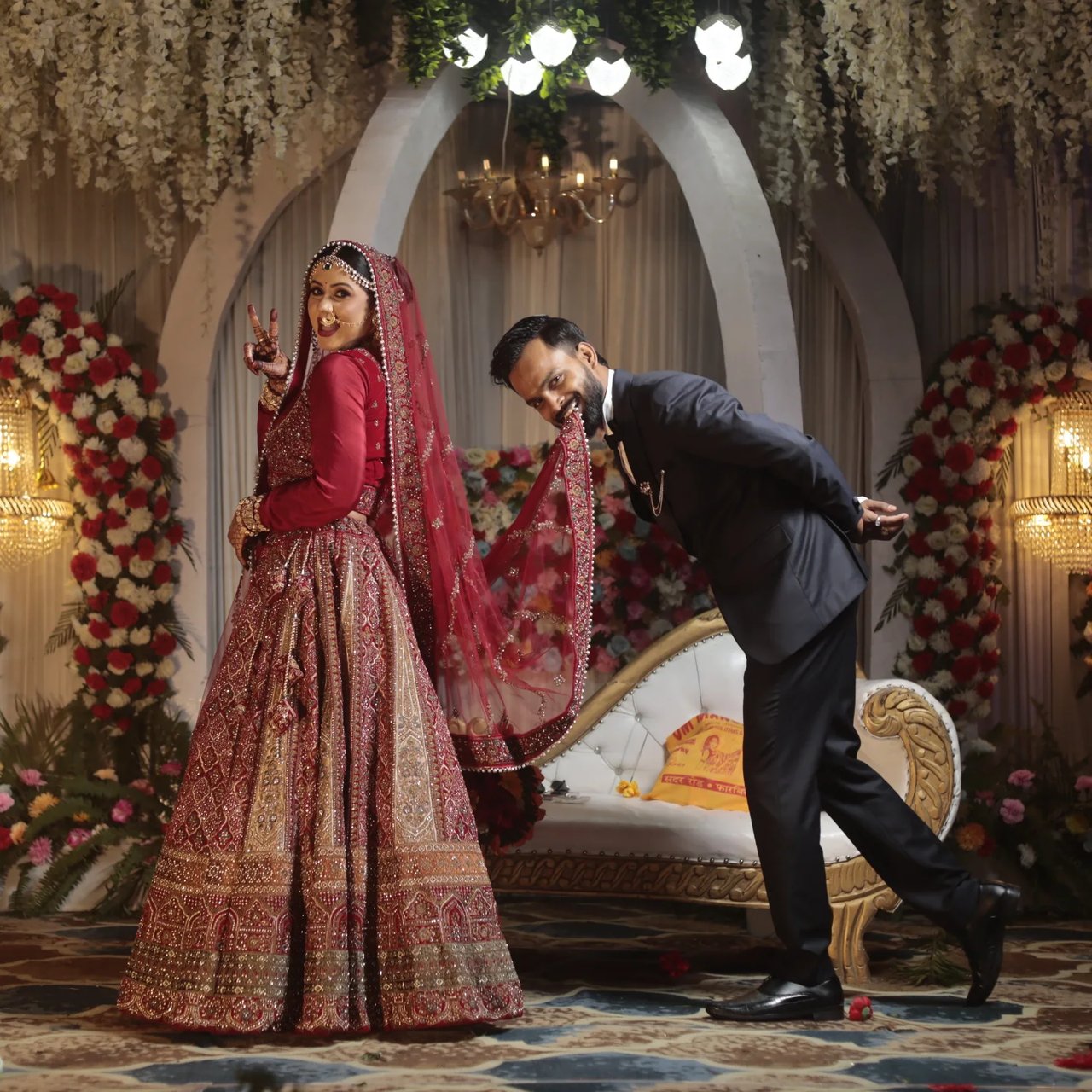 A groom bows playfully to his bride on the stage