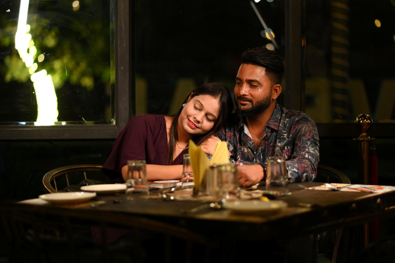 A couple share a candlelit dinner at a café