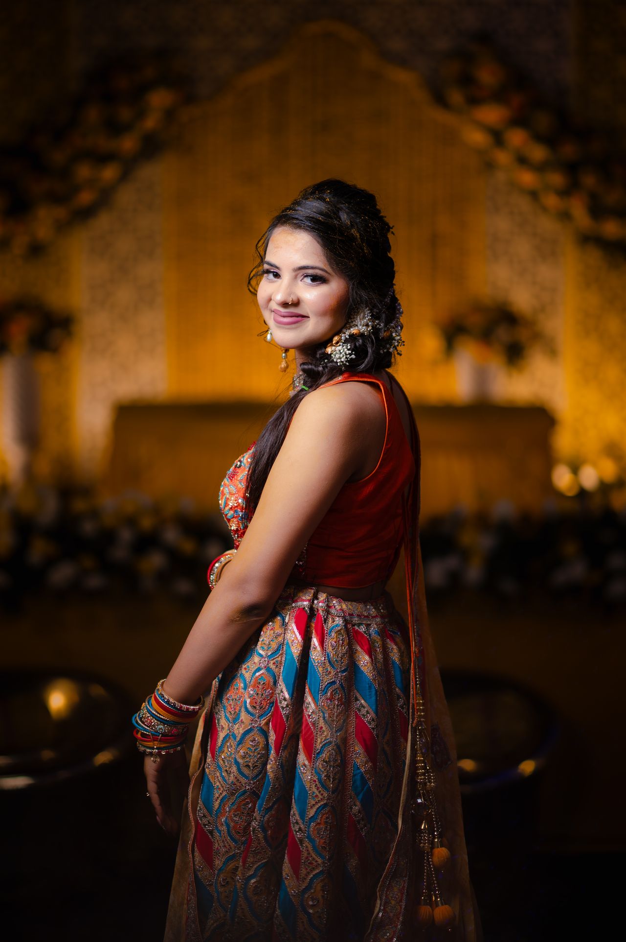 Bride glancing over her shoulder, the stage lights falling away behind her