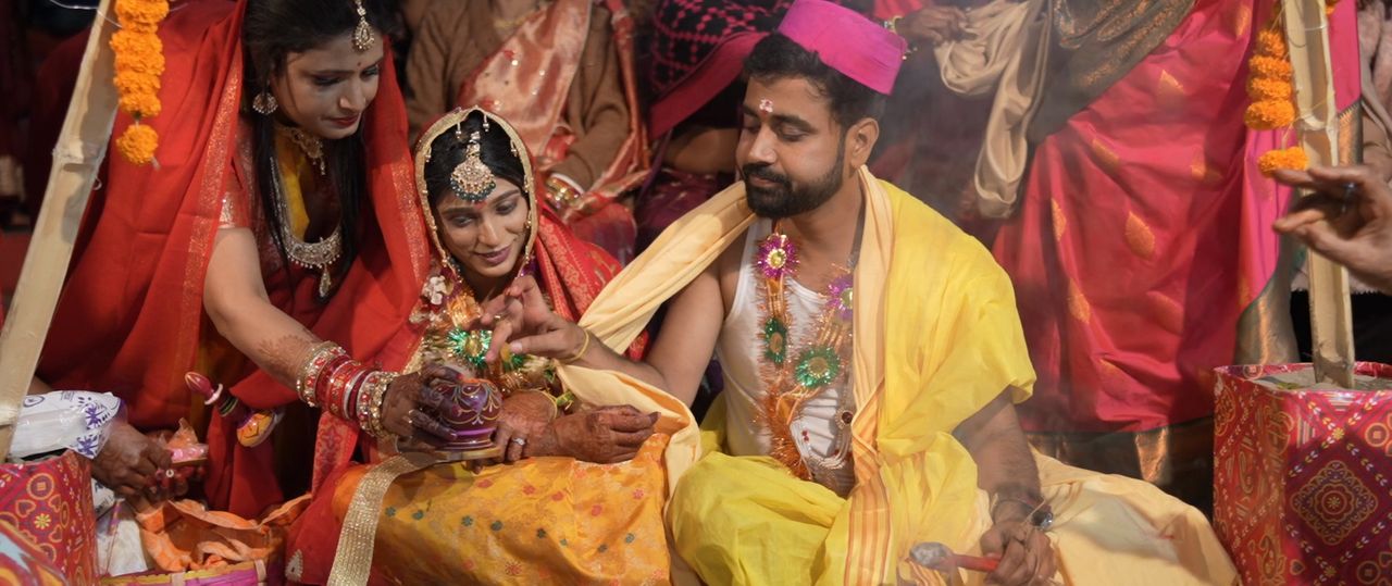 Bride and groom in yellow seated together during the wedding rituals